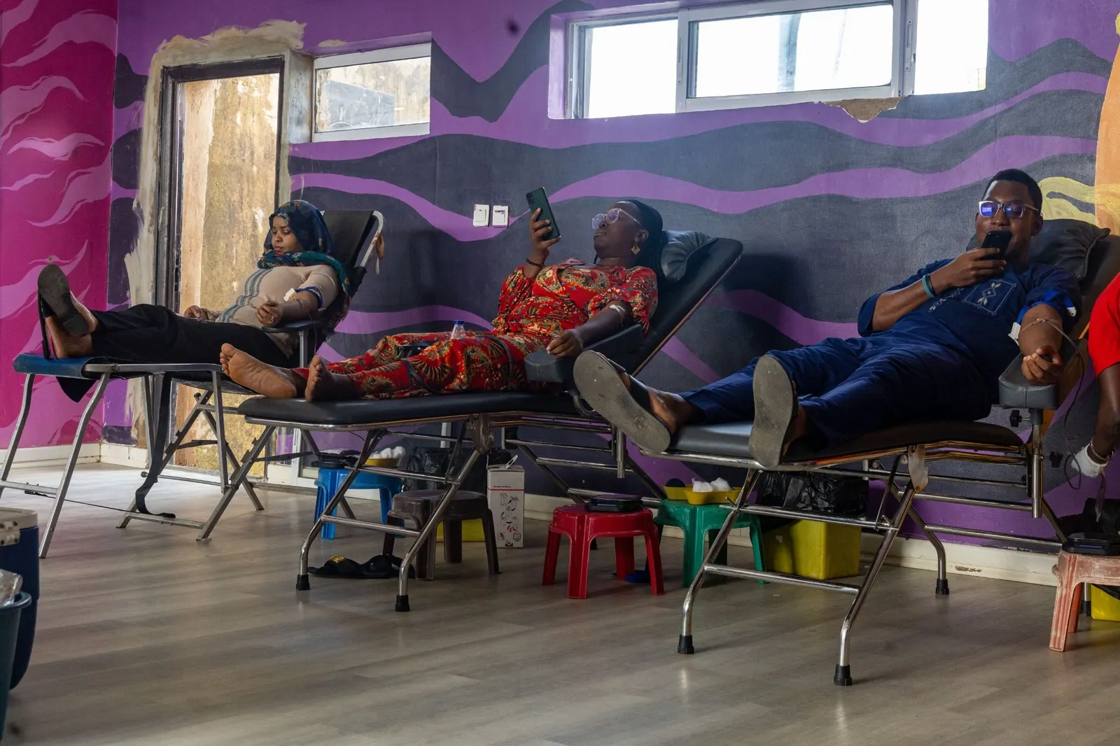 Community members giving blood side by side at a OnePint Plus drive